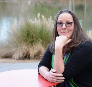 photo of Christine Gautreaux sitting by a lake smiling